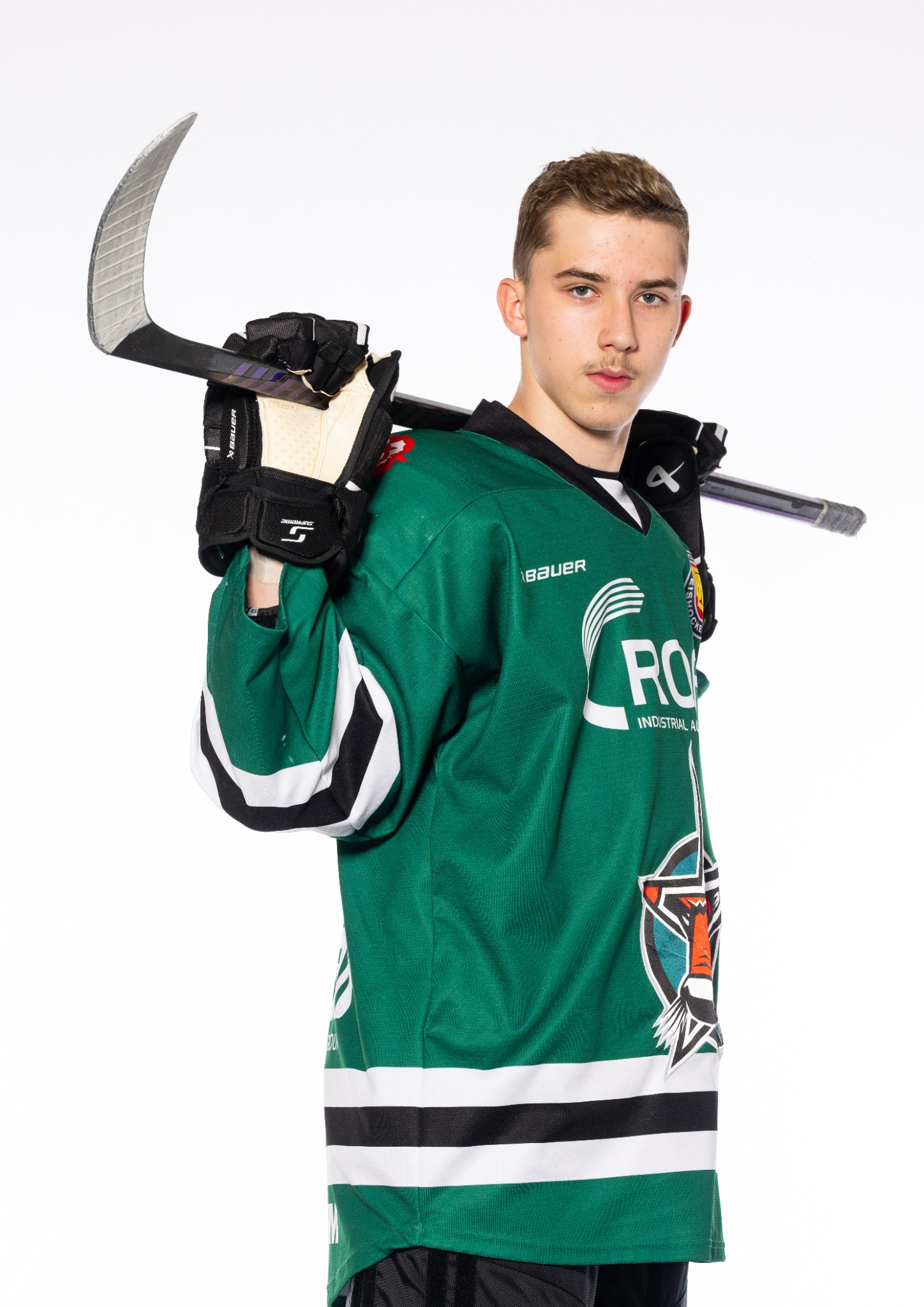 Nik Sušnik in his Starbulls Rosenheim uniform with a hockey stick over his shoulder